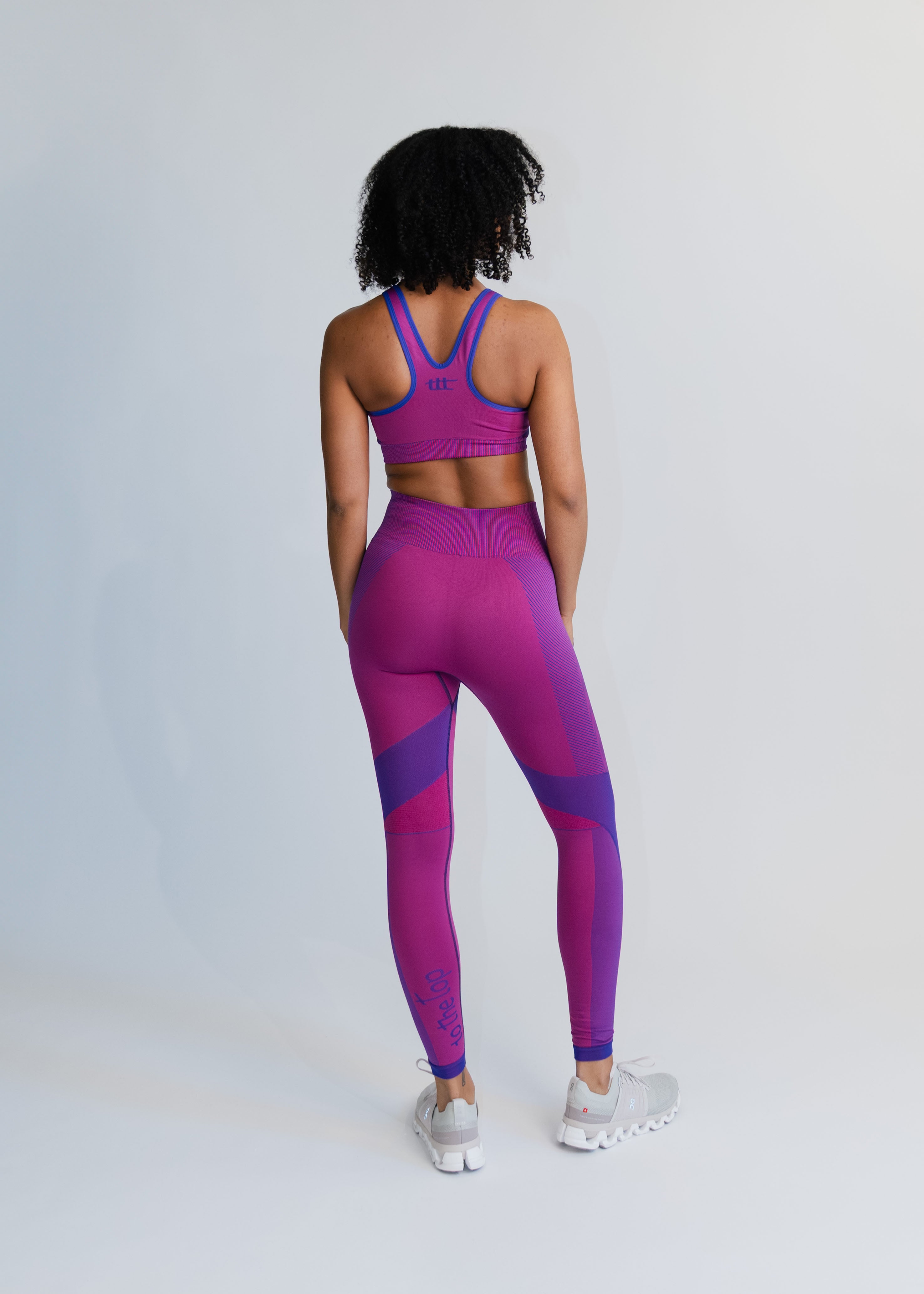 Rückansicht am Model: Sport Leggings in Magenta mit dezenter Rippstruktur und Body-Shaping-Effekt.